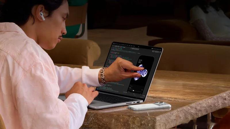 苹果终于让MacBook Pro的屏幕能摸了一下。菜单栏在指尖下会展开，红绿灯按钮变大，动态岛往下拉变成悬浮小部件。十年前Schiller说触屏Mac得把界面推倒重来，现在苹果选了更巧的路——不是重做，是让手指觉得自然。

还有ProLED XDR，黑色够纯，亮度够狠。2899美元起步，说便宜是假的。但一台能摸、能看 ​