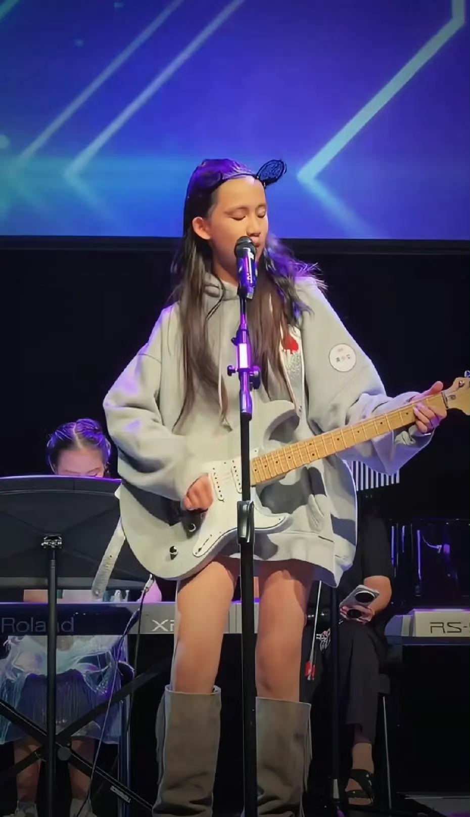 黄磊二女儿黄少艾登台表演，她打扮潮酷，弹着电吉他，唱着歌，太有摇滚范儿了！不得不说，虽说都是一个父母生养，但兄弟姐妹的性格相差很多，大姐黄多多温柔内敛，很有文艺范儿，黄少艾就很外向活泼，古灵精怪，三弟感觉很斯文内向，气质沉稳。