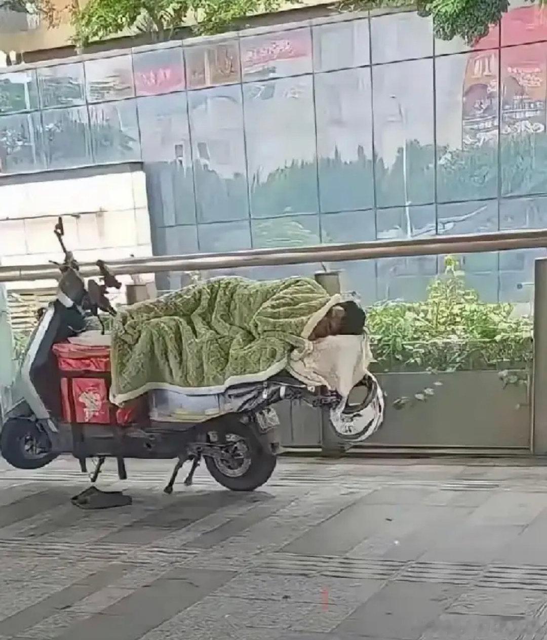 据说这是深圳外卖行业的跑单王，连睡觉都在电动车上，这等神技非常人所能及。 ​
