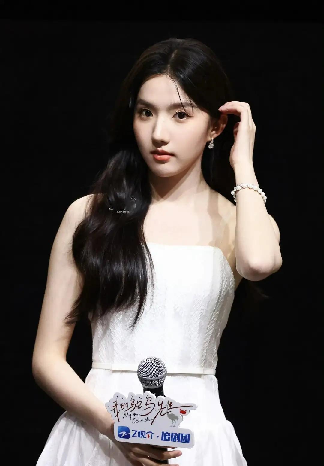 一个穿白色裙子的女孩拿着麦克风。 (苏晓彤)