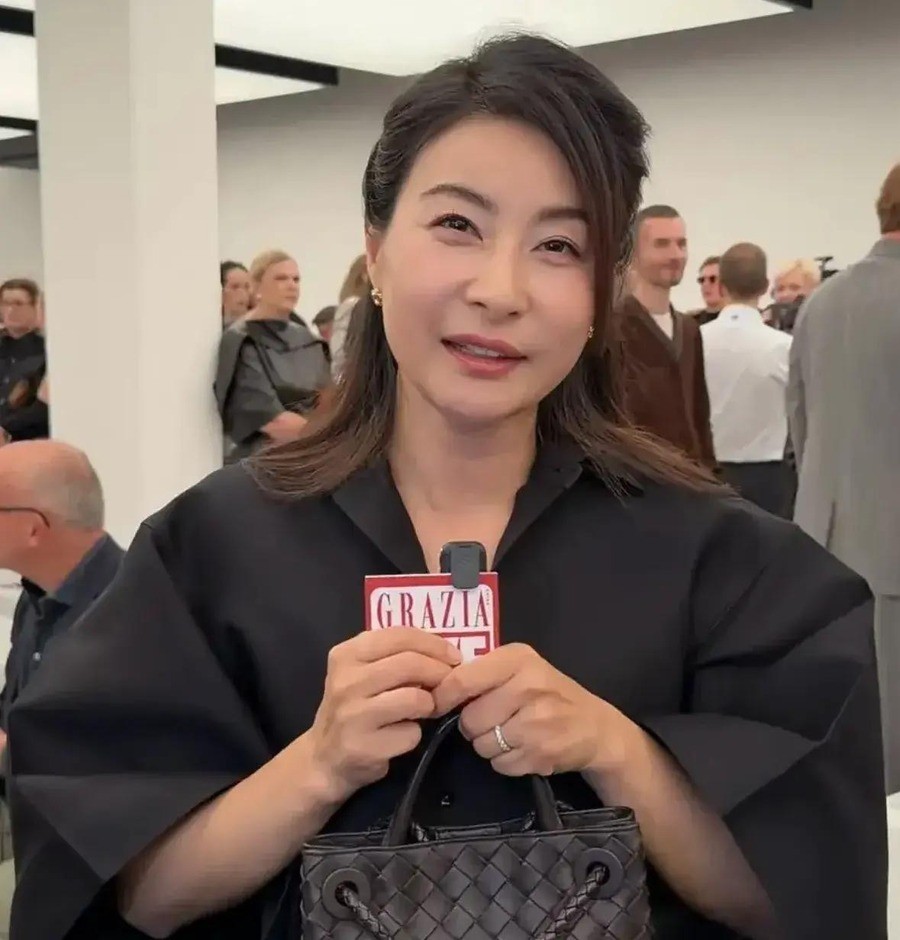 奥运冠军郭晶晶米兰时装周全记录：退役15年手握裁判长文化会副会长多重身份，却说家人永远排第一，44岁穿20万行头跟穿五毛钱发圈一样自在
一身黑色宽袖衬衫配卡其色长裙，脚上那双白色无后跟高跟鞋别致得恰到好处，手里拎的黑色小包上缀着一朵玫瑰花。2026年9月27日，郭晶晶坐在Bottega Veneta