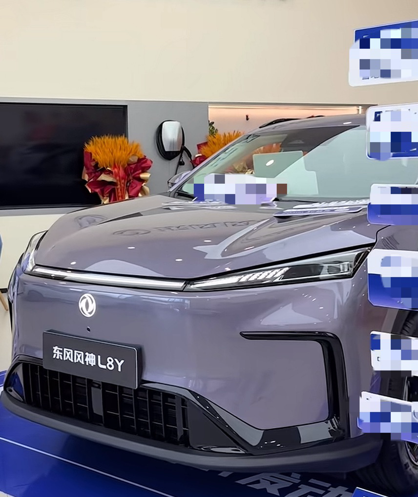 东风风神 L8Y 到店看车：这台纯电 SUV 的静态功夫都在细节里
到店看车，展台上停着的正是东风风神 L8Y。换新后的车标挂在车头，前脸线条收得干净，没有堆太多镀铬装饰，侧面轮廓偏圆润，整体是那种不抢眼、耐看的类型。打开车门，座舱的配色和用料先入眼，浅色内饰配上软包覆盖的中控台，摸上去的触感比这个