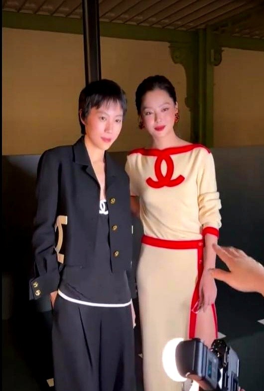 巴黎秀场头排，一个顶着利落短发满脸写着无所谓，一个裹着米色长裙眼角全是冷清。

窦靖童双手插兜往那一坐，身上那股子雌雄莫辨的劲儿，直接把高定穿出了摇滚现场的散漫。

旁边挨着的辛芷蕾，下巴微抬。长裙勾勒出高挑骨架，生人勿近的冷脸硬是压住了全场的浮华。

两个完全不搭界的人凑在一起，就像一杯烈酒兑进了
