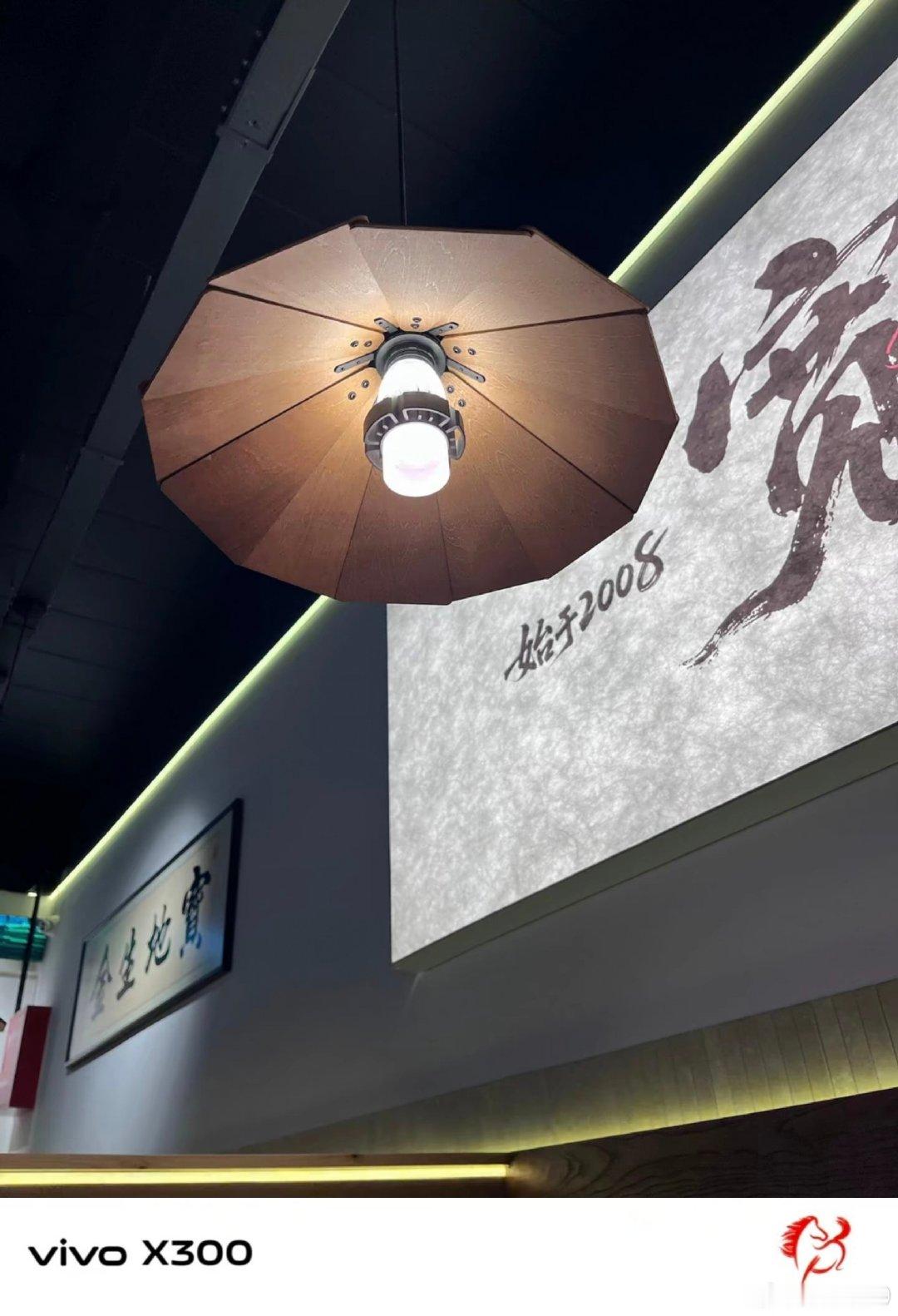 #vivo[超话]##vivo超话#  店里这盏伞形吊灯很有韵味，搭配墙面书法，古朴的细节藏着独有的中式氛围感。 ​