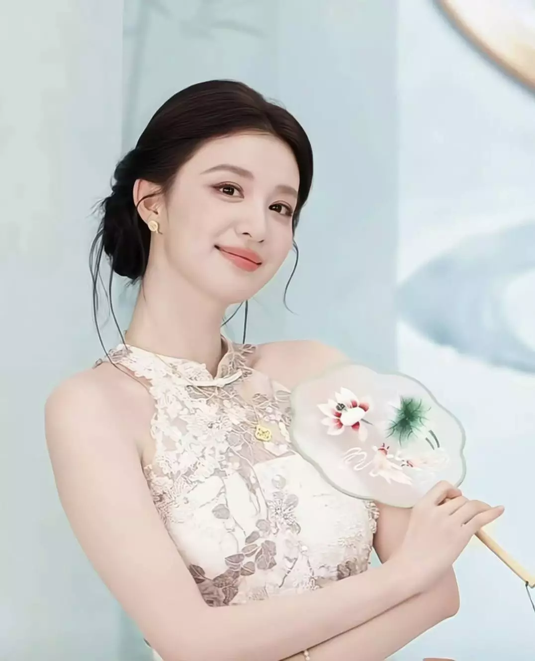 王楚然现身直播活动，她身穿白色蕾丝挂脖旗袍搭配低盘发，手持水墨团扇随机五连拍，温婉又灵动，尽显东方美人气质。