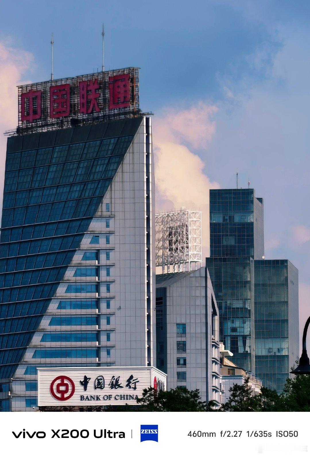 #vivo[超话]# 城市高楼林立，联通大厦线条利落，沪士大厦庄重大气。蓝天白云映衬楼宇，用镜头记录下都市建筑独有的质感与城市蓬勃气息。#vivo超话# ​
