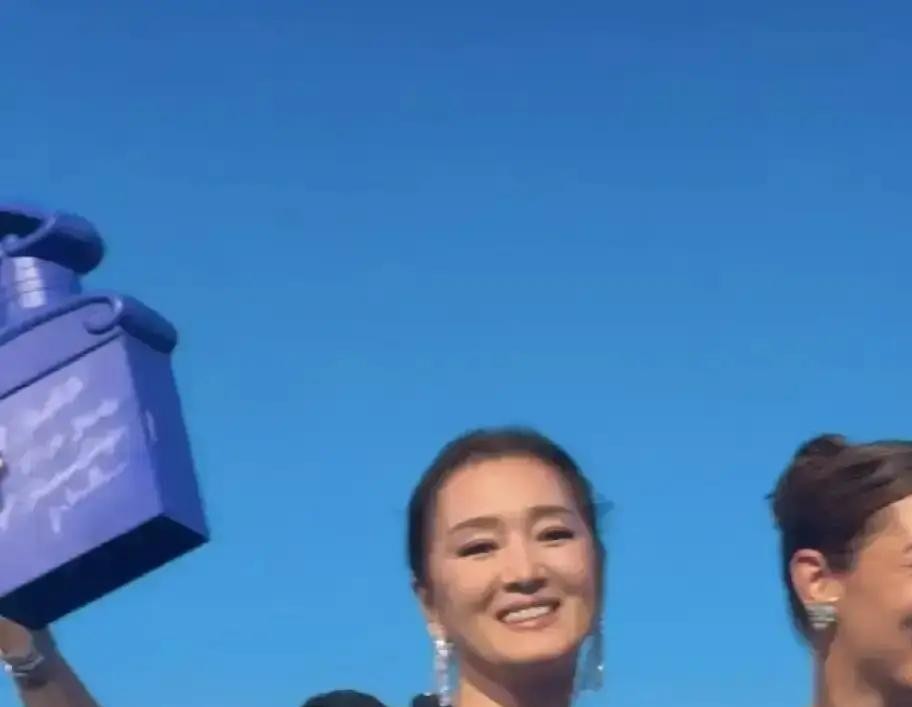 巩皇也会被镜头抓到老去的疲惫，这才是最戳人的地方。8月13日上海西岸娇兰发布会，60岁的巩俐单手插兜压轴上台，杨洋、王鹤棣、章若楠同场，合影C位还是她。可生图一出，白发、法令纹、颈纹、微凸的小腹被网友拿着放大镜审，一边喊"巩皇老了"，一边又有人嘲"连装都装不动了"。
我看这事，本质是公众对女明星的年