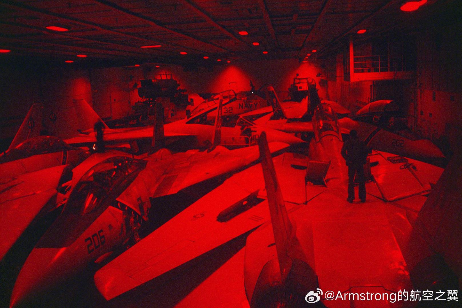 #烽火问鼎计划# 航母机库中的大猫。F-14在75°后掠状态下，整体轮廓呈现出非常规则的尖锐三角翼几何体。地勤人员会将多架F-14以“头对头、尾对尾”或“前机机头嵌入后机两翼之间”的交错方式紧密排列。F-14可以像拼图一样扁平地贴合在一起，甲板利用率甚至超越了机翼向上折叠的F/A-18系列。 ​