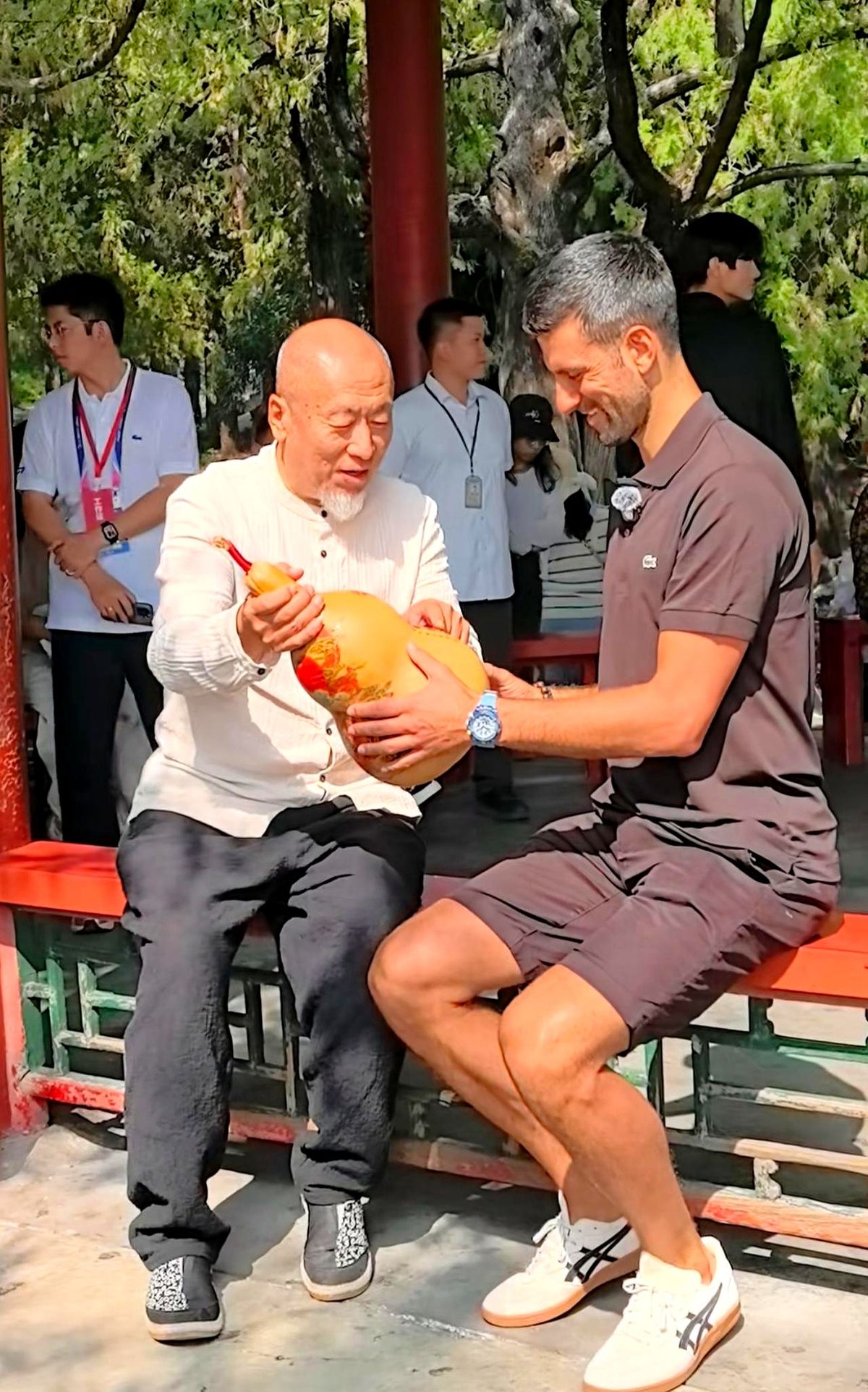 德约科维奇在颐和园捧着个大葫芦，对面站着个滔滔不绝的北京大爷。

大爷拿着手里的“法器”，一口中文娓娓道来。再看对面的网坛巨星，明显一句没听懂，但表情一本正经，全程跟着大爷的语速认真点头。

这跨国跨语言的同框，直接整出了西游记名场面的既视感。

就这无缝衔接的捧哏态度，德约以后不打网球了，来中国发