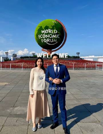 郭晶晶和老公霍启刚出席达沃斯论坛，她身穿米白色立领衫配柔粉长裙，素雅又...