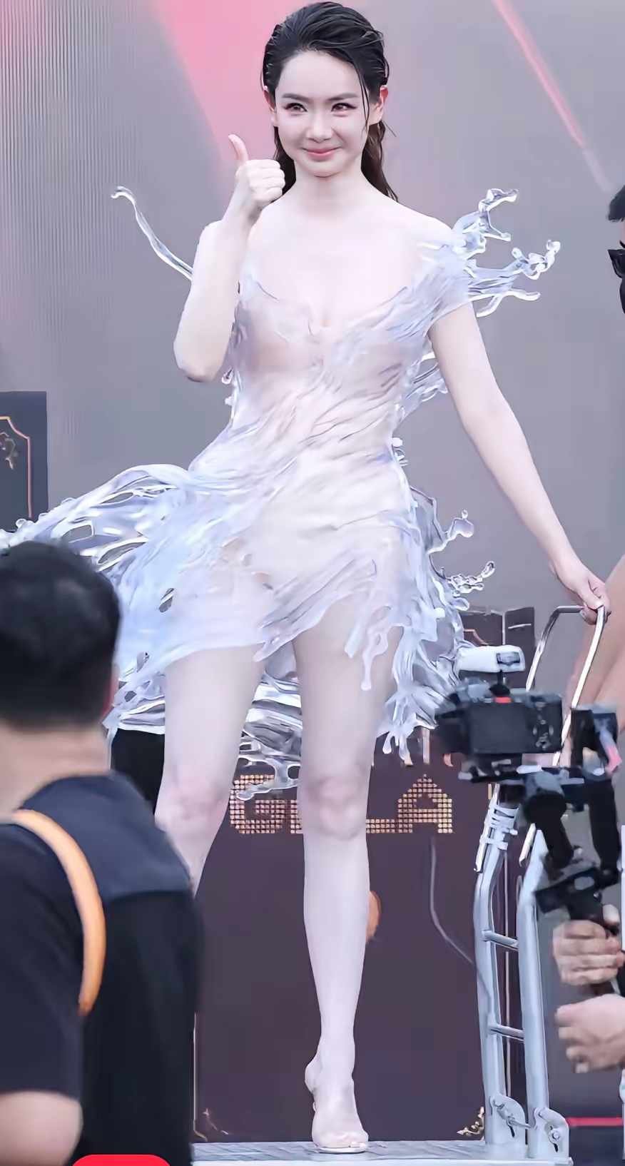 谁懂啊！戚薇红毯一出来，像刚洗完澡没擦干就上台了😂

头发贴脑门，裙子像一盆水“哗”地泼身上，水珠水浪全冻住了。旁边还摆个特朴素小推车，豪华感和潦草感撞一起，太违和。

有人夸“水花”创意绝了，像把大海穿身上；也有人直说太透太敢，眼睛不知道往哪放。红毯就是这样，越怪越有流量，越看不懂越上热搜。

艺