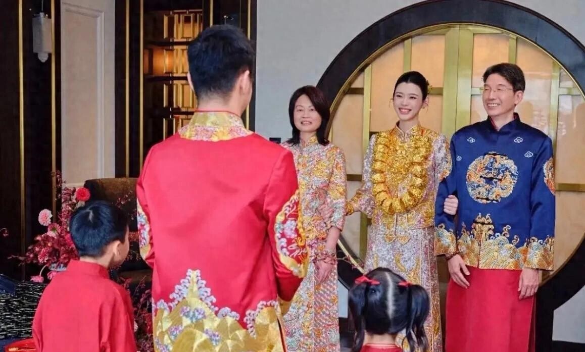 奚梦瑶补办婚礼，金镯子晃眼，墙上那幅画才真让人感慨
十月一号下午，账号“嘻嘻哈”甩出一组奚梦瑶的婚礼照片。中式嫁衣、龙凤镯、全家福，该有的排面都有。我翻来覆去看了几遍，目光停在她和四太合照的背景墙上——赌王何鸿燊的照片挂在那儿，一家人就这么同了框。
这场婚礼，说是补办，更像一次交代。奚梦瑶跟何猷君领