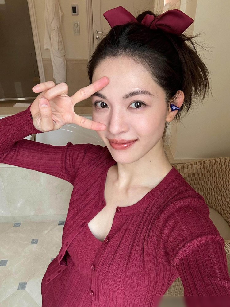 钟楚曦这身酒红针织，把“甜”和“狠”焊死了。
细坑条吊带贴着锁骨走，高马尾扎个蝴蝶结，胶片颗粒一压，秋日氛围直接拉满。不是那种软塌塌的甜，是带着棱角的酷。
转头看她待播剧的路透，白衬衫配牛仔阔腿裤，翻领风衣里塞条飘带衬衫，走的又是高知清冷那挂。前脚自制口红盘被时尚镜头追着拍，后脚穿LV戴无框眼镜