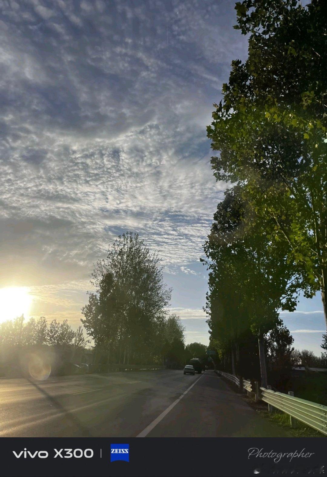 #vivo[超话]##vivo超话#  走在公路上迎着落日，阳光穿过枝叶，漫天碎云，这一路的风景真的越看越喜欢。 ​