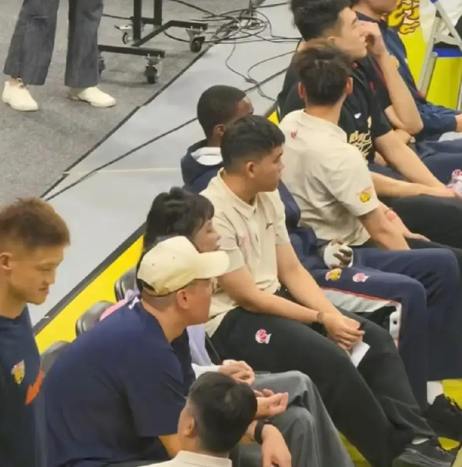 广东宏远新赛季首个主场比赛，场边最吸睛的居然不是场上球星，而是顶着新发型、脚踩拖鞋的老板娘吴迪。
身家摆在那里，但到了球场边上，这位宏远女当家根本不屑于摆什么阔太架子。
旁边坐着儿子，另一侧靠着老搭档朱芳雨，几个人场边有说有笑，聊得那叫一个松弛，完全看不出主场揭幕战的紧张气氛。
吴迪这次特意倒