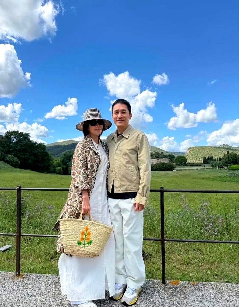 刘嘉玲踩着高跟鞋迈下台阶，顺手盘上了梁朝伟刚剃的寸头。

换作旁人早下意识偏头躲了，但这位影帝毫无避让。他的脑袋顺着媳妇的手势微微低垂，乖乖贴着她的掌心往前挪步。

这事发生在南法小镇的花房外。没了红毯和镜头，这对互补了三十多年的老夫老妻彻底交了底。前一天她刚发文说从容以待，转眼就在街角把这四个字演