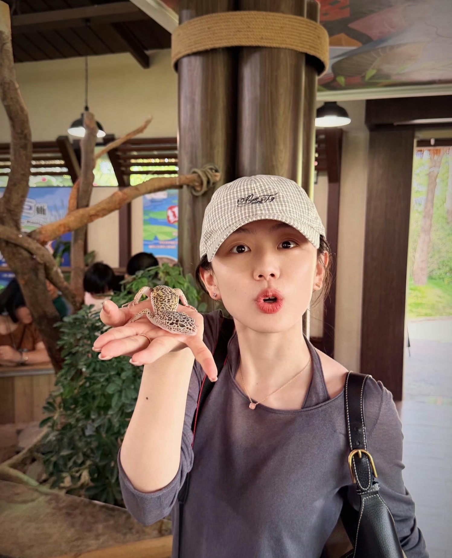 冯禧婚后分享生活照，她以素颜轻松状态出镜，头戴格纹刺绣棒球帽，身穿灰调假两件休闲上衣搭配简约细项链与黑色挎包，整体穿搭随性松弛，完全没有刻意营业的感觉，笑容灿烂松弛，完全没有舞台上的主持紧绷感，尽显日常的轻松自在。
她手掌上托着的是一只豹纹守宫，身上布满标志性的黄黑相间豹纹斑点，和她配文里提到的“撞