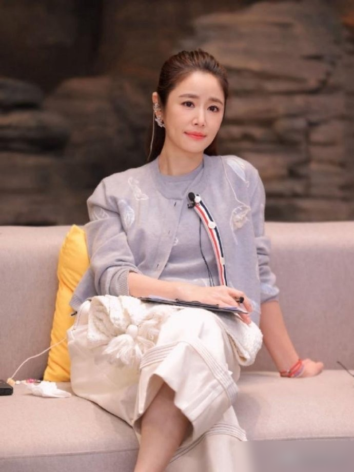 48岁林心如站在九寨沟游客堆里，原相机怼脸拍，小腹微凸，双下巴都出来了。
结果她一点没躲，自己先笑：侧脸看是不是很明显？
游客喊她比耶，她凑过去就拍，素颜，松垮的米色开衫，白裤子被风吹得贴在腿上。皮肤紧，气色好，笑起来眼角堆着纹路，反倒比精修图里那张脸生动多了。
评论区一边倒：这状态真舒服，比