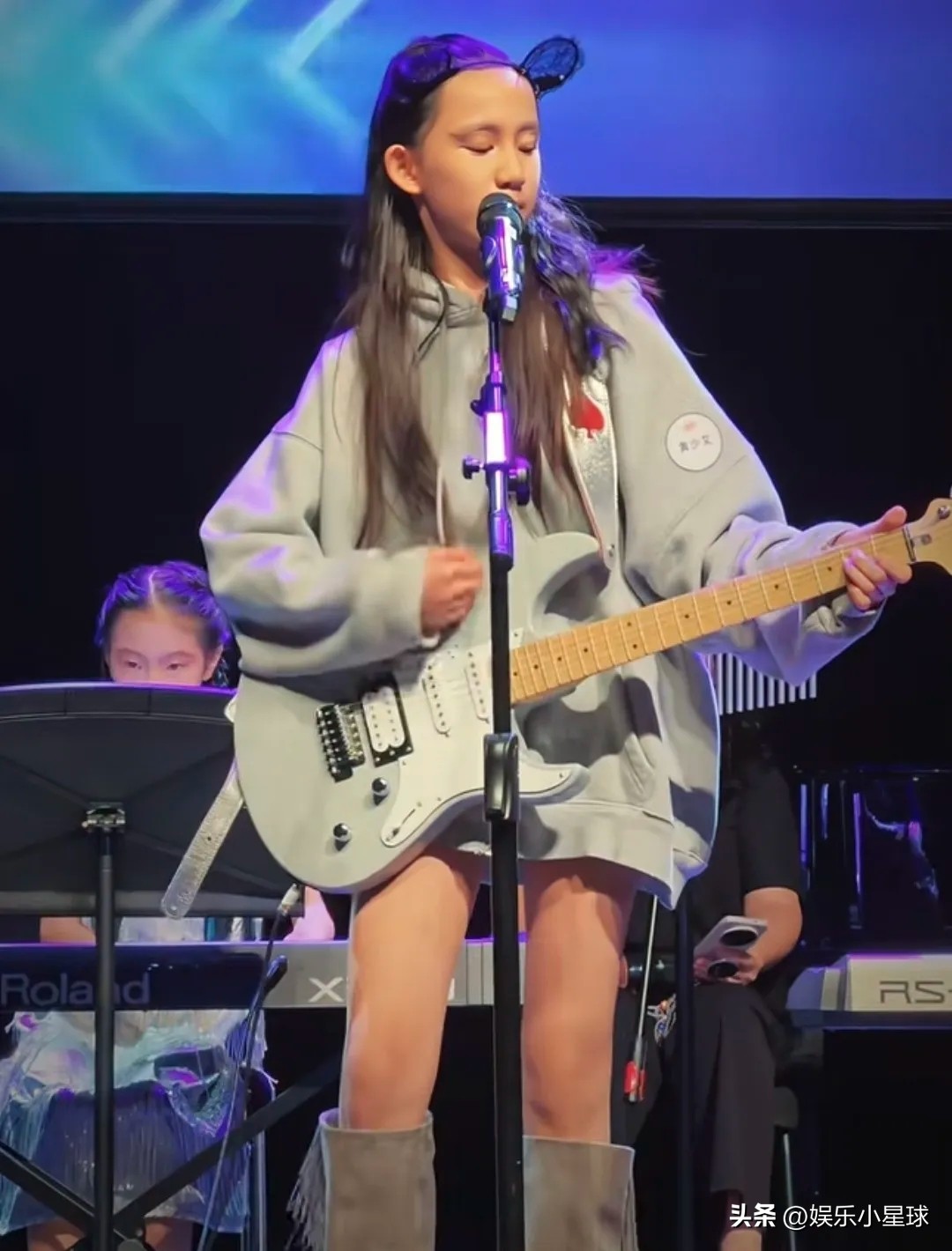 黄磊孙莉的二女儿黄少艾，12岁就把家里的舞台风格“拧”出了新方向。孙莉晒出的现场里，她穿长靴、披长发，抱着电吉他登台，动作和造型都透着一股摇滚范。

姐姐黄多多已去纽约读大学，妹妹因此成了家中新的关注点。和多多小时候的灵动路线不同，黄少艾更爱音乐，也更敢表达，演出服、妆容都由自己挑，古灵精怪里带着成