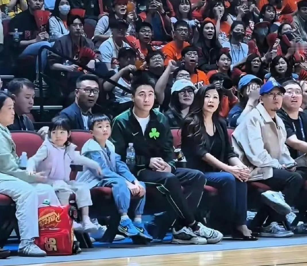 何猷君一个人带着儿子女儿现身篮球赛看台，镜头扫过的那几秒，比球场本身还抢戏。
两个小家伙挨着爸爸坐，脸型柔和、眉眼清秀，就是最典型的中国娃娃长相。赌王家族那点混血底子传到这一代，已经被冲得几乎看不见了，奚梦瑶的基因确实强势。
唯一没被盖住的破绽在眉毛——儿子那两道弯弧，跟何猷君几乎是一个模子刻出来的