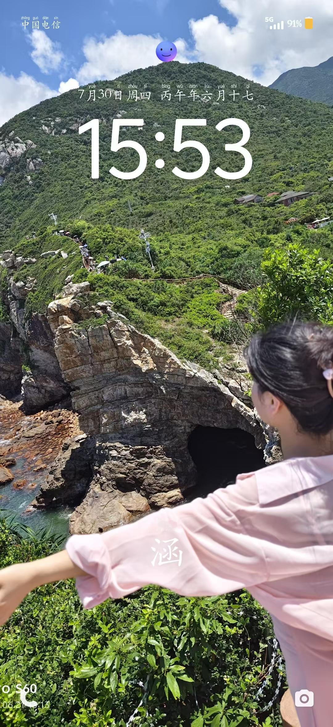 这张图片拍摄于**深圳大鹏新区的杨梅坑鹿嘴山庄**，这里是电影《美人鱼》的取景地，也是深圳著名的网红打卡点。以下是关于该地点的详细信息：**地标背景**：鹿嘴山庄位于深圳大鹏半岛的最南端，拥有独特的山海景观。图片中标志性的**海蚀洞**和悬崖栈道，因电影《美人鱼》中邓超和罗志祥“跳海”的经典场景而广