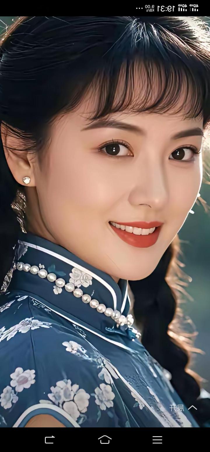 这位美女穿着新中式旗袍，戴着珍珠项链与耳环，微笑自然散发出古典韵味！