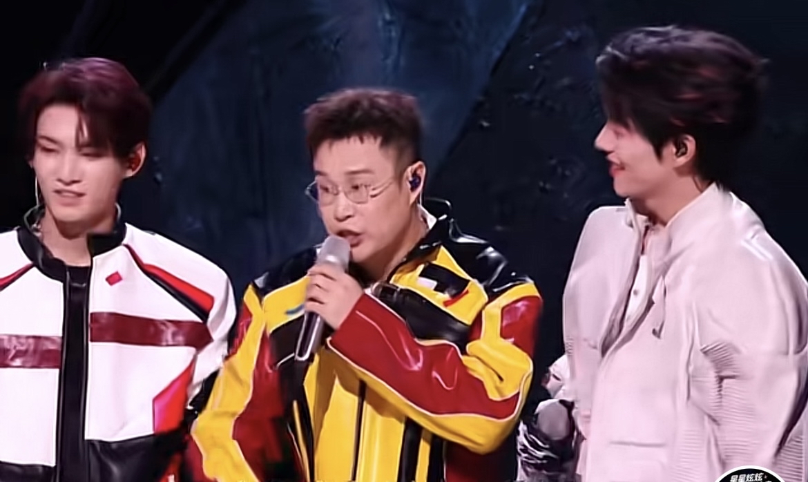 《披荆斩棘2026》一公舞台，小沈阳、姚琛、曾辉三人合作演绎《爱的主打歌》，一改大家印象里的风格，带来一场热烈十足的唱跳舞台。

小沈阳一身亮眼的黄红拼色赛车风外套，手握麦克风气场全开。很多人只记得他的高音，这次却突破自我，努力跟上唱跳节奏，一边演唱一边完成舞蹈动作，舞台感染力拉满。哪怕表演途中遇到