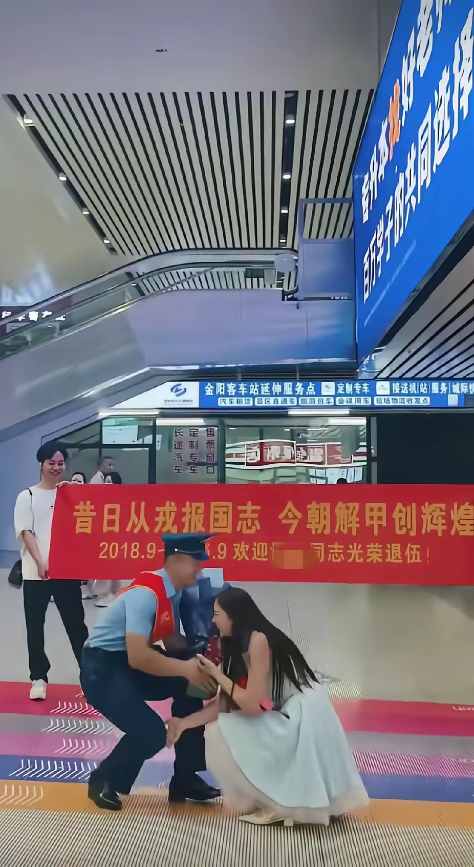 火车站出站口，一名女子突然单膝跪在一位军人面前，女子接下来的一个举动，更是让人直呼感动了
浙江的一个火车站，一名身着军装，身披大红彩带的军人，快步向出站口走去。
出站口前，一名年轻女子，手捧鲜花，满眼温柔地看着走出站口的军人。

周围人还没反应过来，她膝盖已经落地了。不是那种软绵绵的作秀，是干脆利落