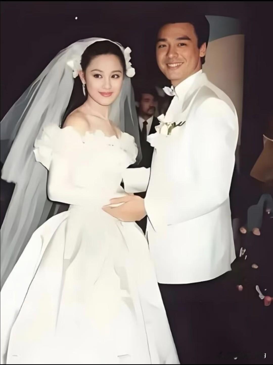 这是1988年钟镇涛与章小蕙的婚礼婚纱照。
当年钟镇涛和章小蕙举办盛大婚礼，章小蕙一身复古露肩婚纱，头纱搭配花朵装饰，惊艳香港娱乐圈。那时两人甜蜜相拥，是当年万众羡慕的金童玉女，只是谁也想不到这段婚姻最后走向破裂。