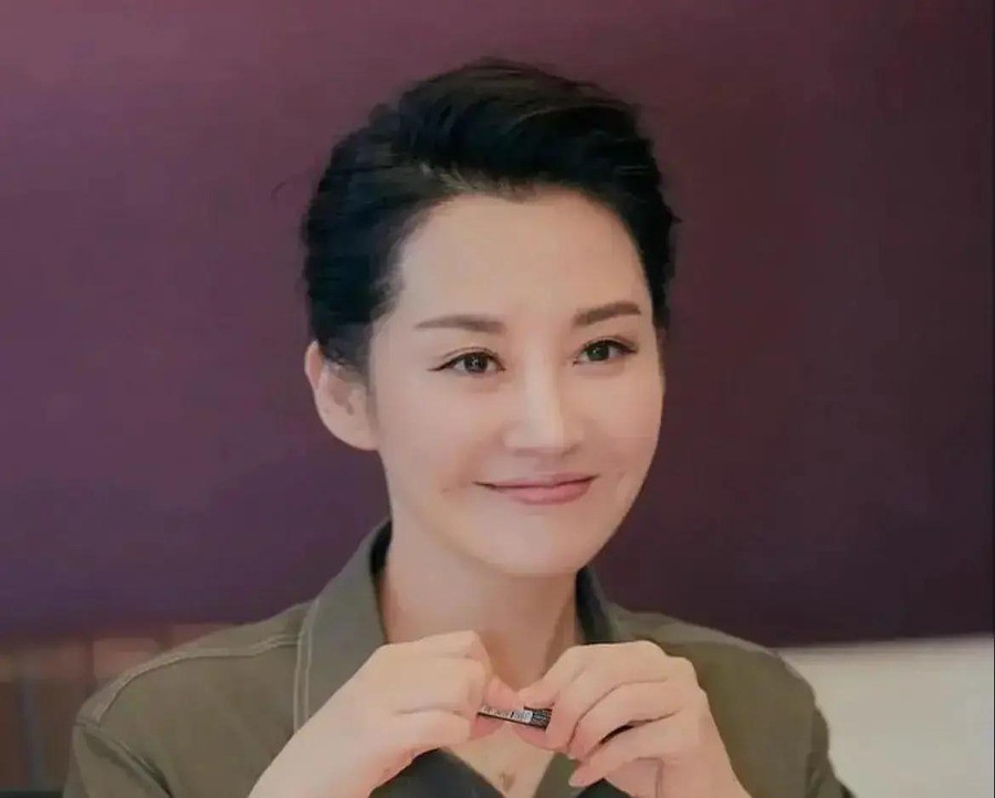 许晴57岁演《如梦之梦》，一场戏份4个多小时，绕场走5公里，演出时长6小时20分钟。下台穿白裙配玫红运动鞋，评论区骂她装嫩。
骂她的人不少。2026年8月机场那组照片出来，白裙，玫红厚底运动鞋，高丸子头，黑框眼镜。有人说她苹果肌饱满得过分，笑起来肌肉走向僵硬，医美过度，反而没了自然感。有人拿她和蒋雯
