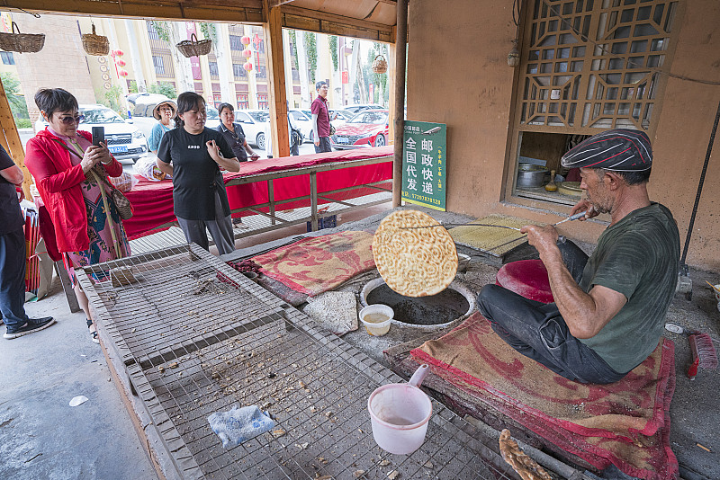 直击西安阿达西烤馕现场 
我说句实在话，同样大小的馕，在新疆本地卖得都比他这儿贵，新疆本地一个就要六块，这兄弟真的太实在了，十块钱能买三个。老远就能闻见烤炉里飘出的麦香混着芝麻香，刚出炉的馕个个圆鼓鼓的，表皮烤得金黄焦脆，掰开还能看见内里层层叠叠的软韧面芯，撒的白芝麻和洋葱碎给香气又提了好几个度。