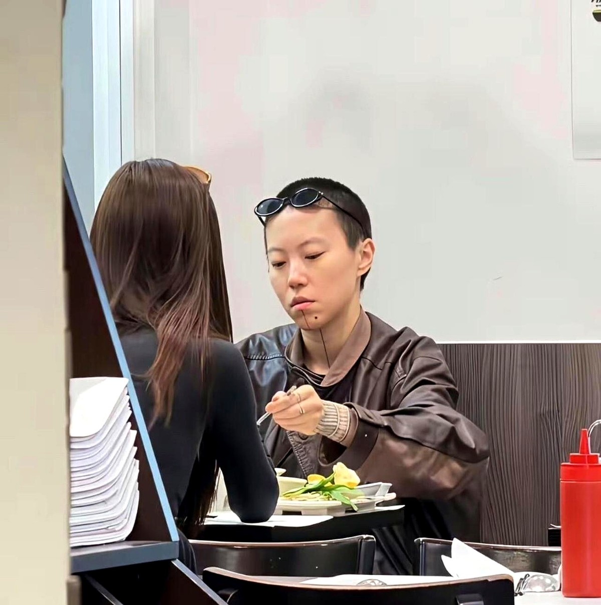 巴黎街头，窦靖童端着一碗汤面，被人怼脸拍了。

照片传回来，评论区炸了，一堆人说她不配被喜欢，说她没有松弛感。

我就纳闷了，一个29岁留着寸头、带着纹身的姑娘，就那么坦然地坐在马路牙子上吃面，被人认出来也不躲不藏，这还不叫松弛感？难道非得在高级餐厅里摇晃红酒杯才算？

都说她沾了王菲的光，这话没错