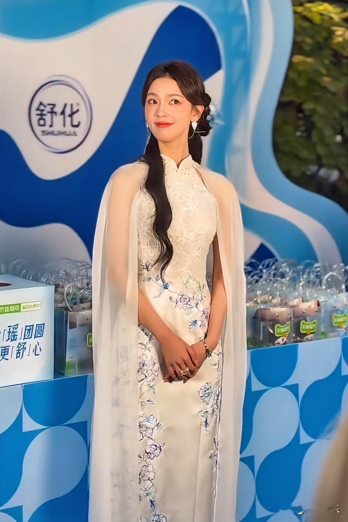 谁懂！
陈瑶这身旗袍美得像从古画里走出来。

陈瑶这次出席线下活动的造型真的很亮眼，一身浅底带蓝纹的改良旗袍，外搭飘逸的透纱披风，头上简单配了小花发饰，古典韵味一下子就出来了。
她身形纤细挺拔，站在现场笑意清甜，整个人温柔又灵动。很多人都记得她在《老九门》里的演绎，这次露面状态稳定，这种国风造型和她